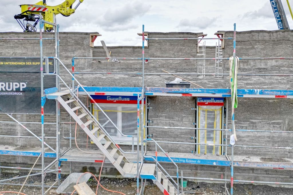 Serielles Bauen: Während im Erdgeschoss bereits die Windowment-Elemente mit Fenster von Gugelfuss eingebaut sind, wird im Obergeschoss weitergedruckt. Foto: Ingo Jensen/Gugelfuss