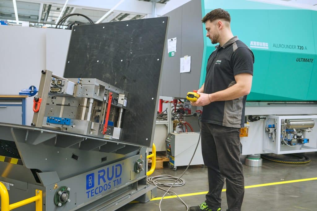 Turning tools weighing tons in a matter of seconds at the touch of a button: An Arburg employee operates the RUD Tecdos TM. Photo: Ingo Jensen/RUD