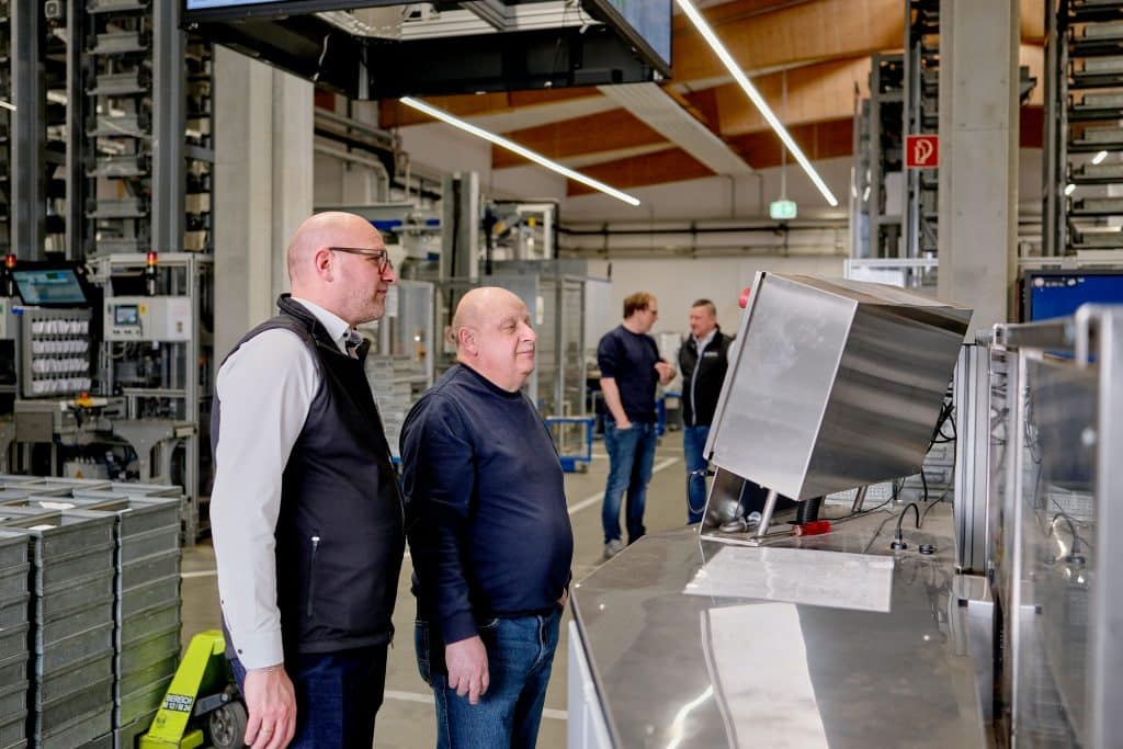 Helmut Mühlberger, Gruppenleiter Einzelteilfertigung bei Rosenberger (links), und Michel Lubinsky-Fischer, Vertriebsbereichsleiter Oberflächen- und Textilreinigung bei der Richard Geiss GmbH, kontrollieren den Reinigungsprozess. Foto: Ingo Jensen/Richard Geiss GmbH