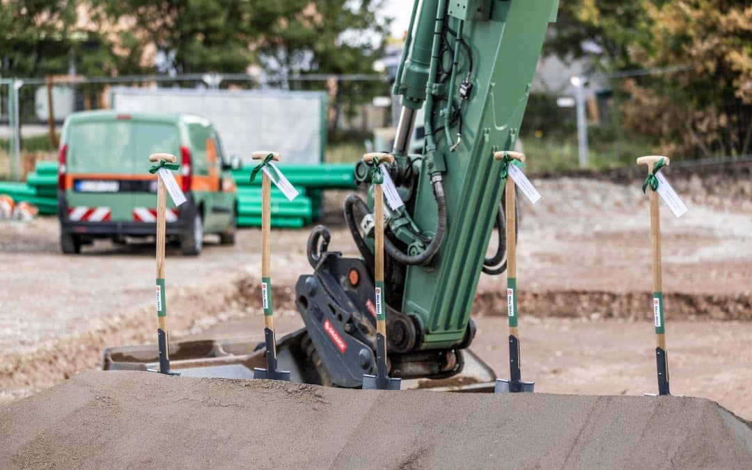 Die Spaten in der Baggerschaufel stehen sinnbildlich für den Beginn der Bauarbeiten. Foto: Wild Projektentwicklung